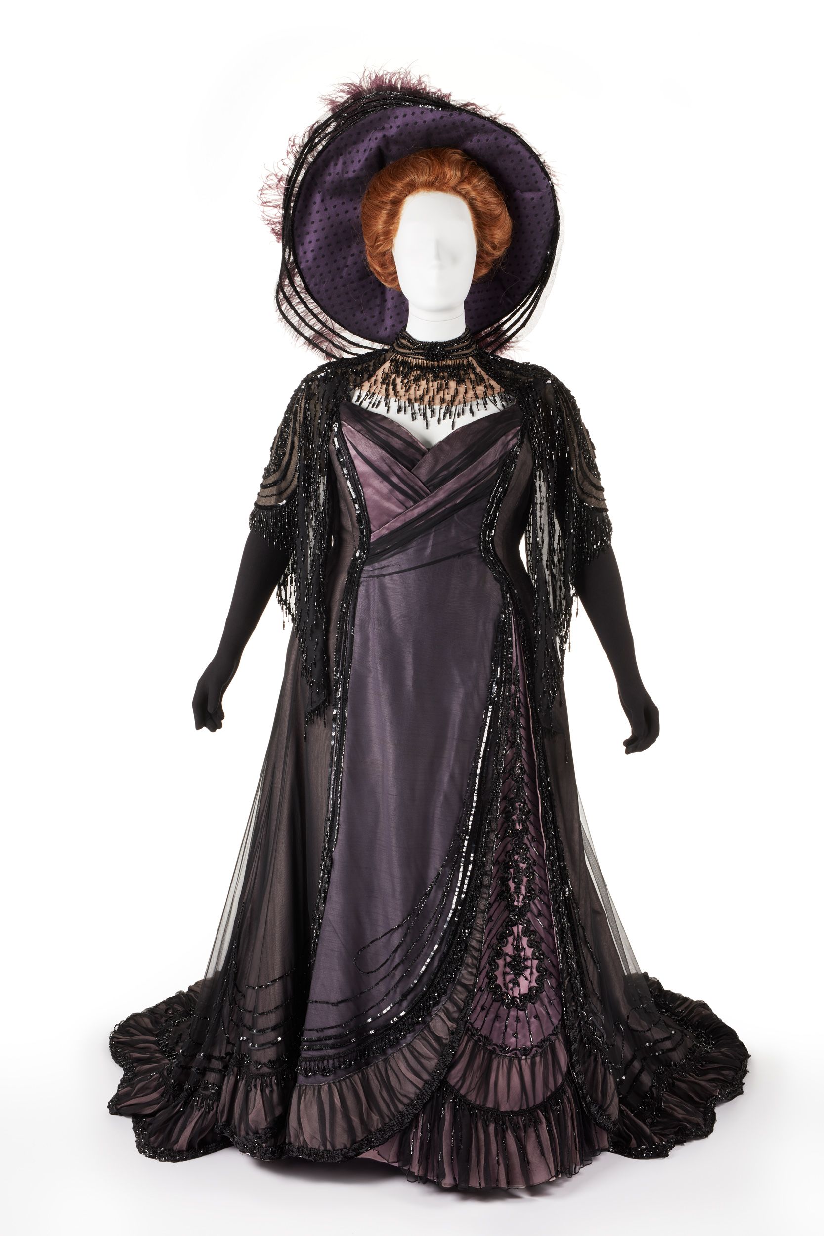 A purple dress and hat with long skirts