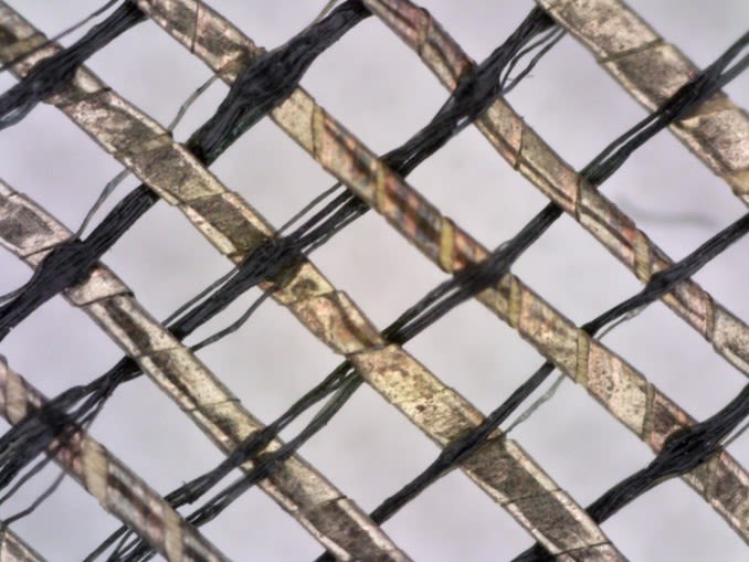 A microscope image of diagonally crossing gold and black fibres