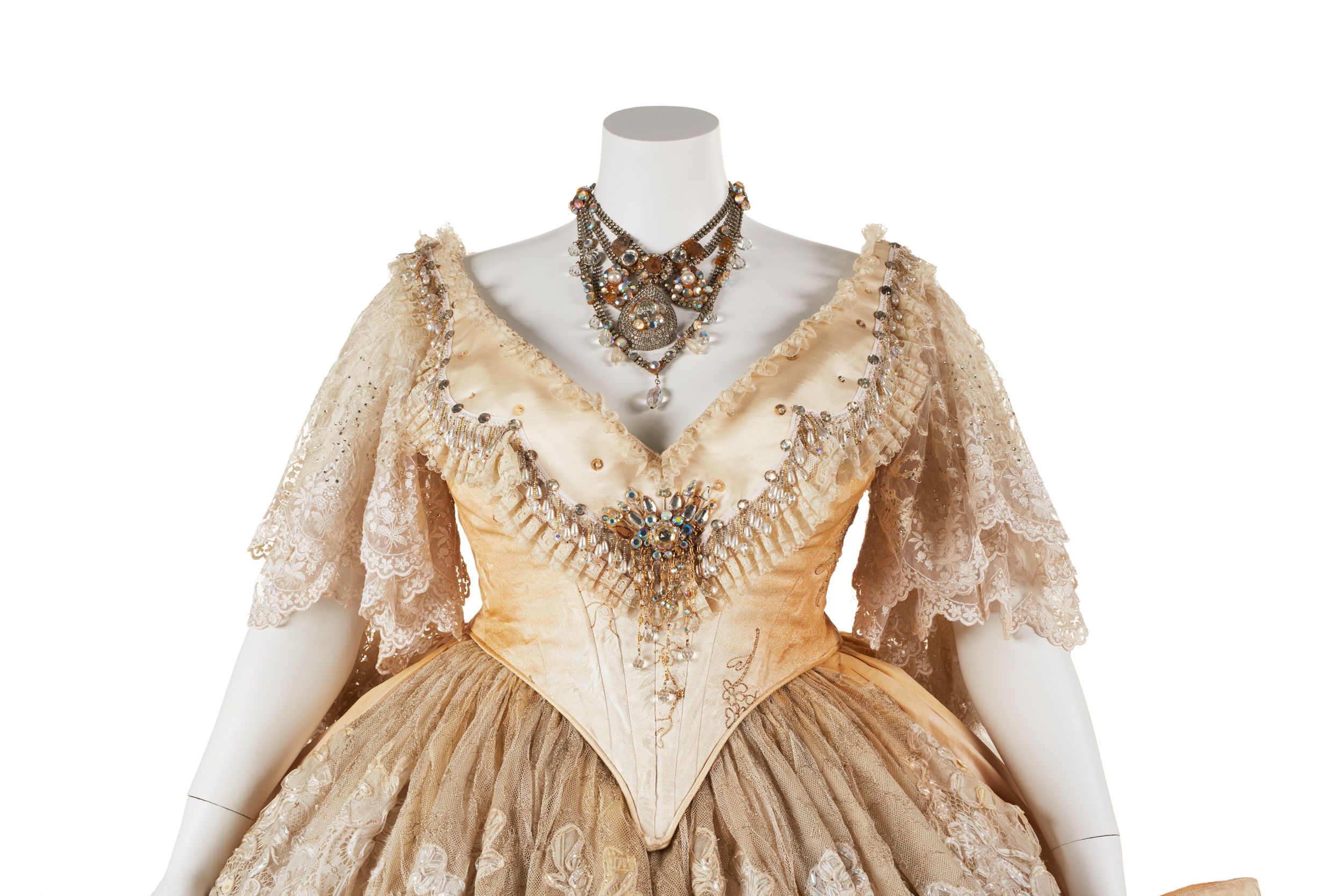 An elaborate cream coloured costume with lace sleeves on a mannequin