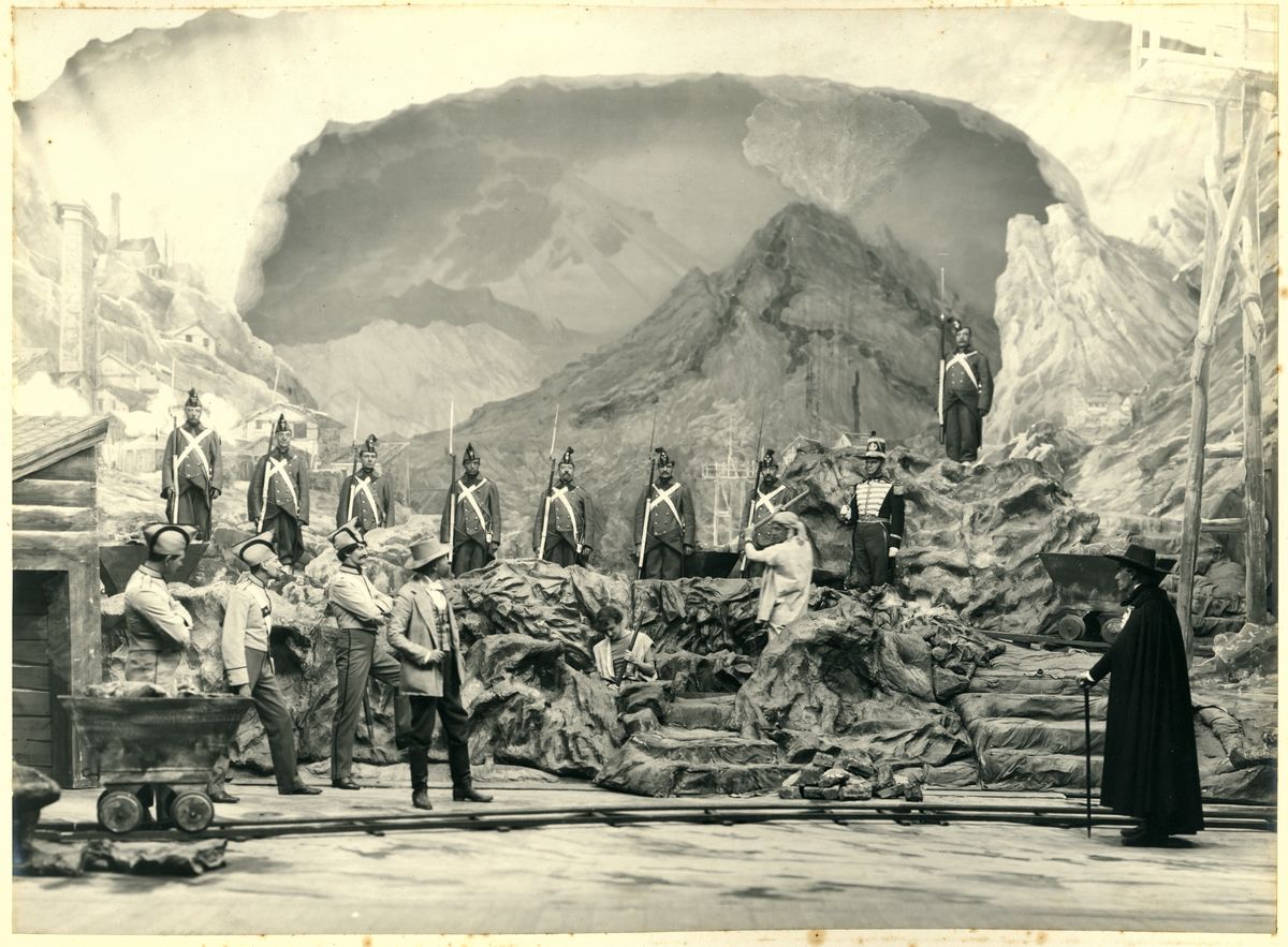 A stage backdrop depicts a mountain scene, with rows of soldiers holding bayonets.
