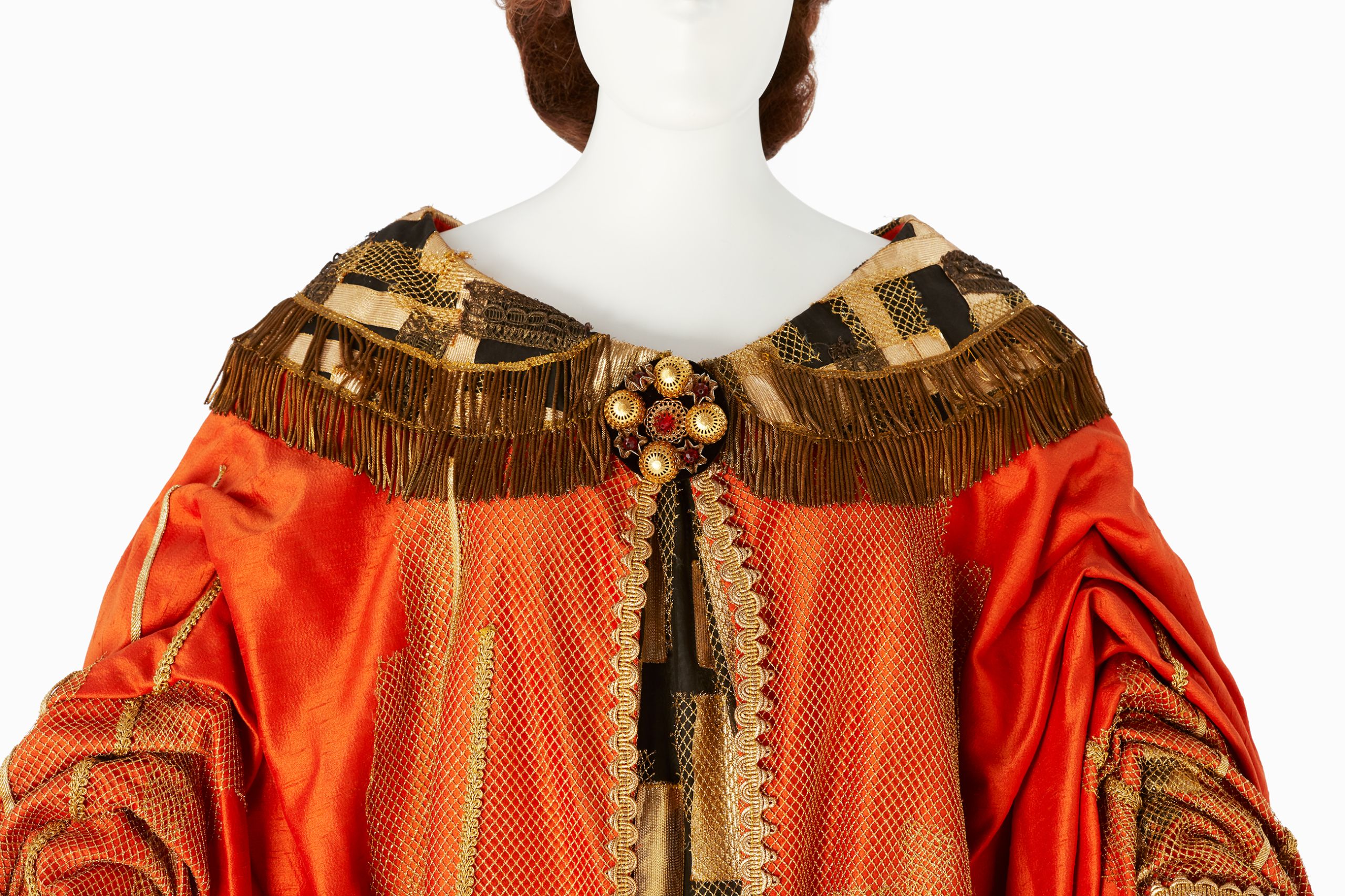 Costume worn by Joan Sutherland for the title role of Semiramide, 1965. The costume is made from heavy orange fabric, with gold detailing and fringing.
