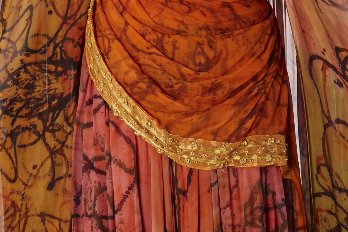 Detail of skirt showing gold beading and fabric.
