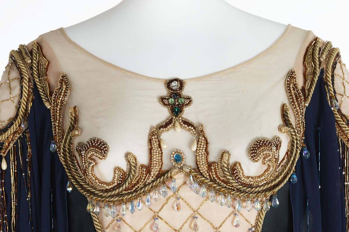 Detail of dress bodice with gold trim and beading.