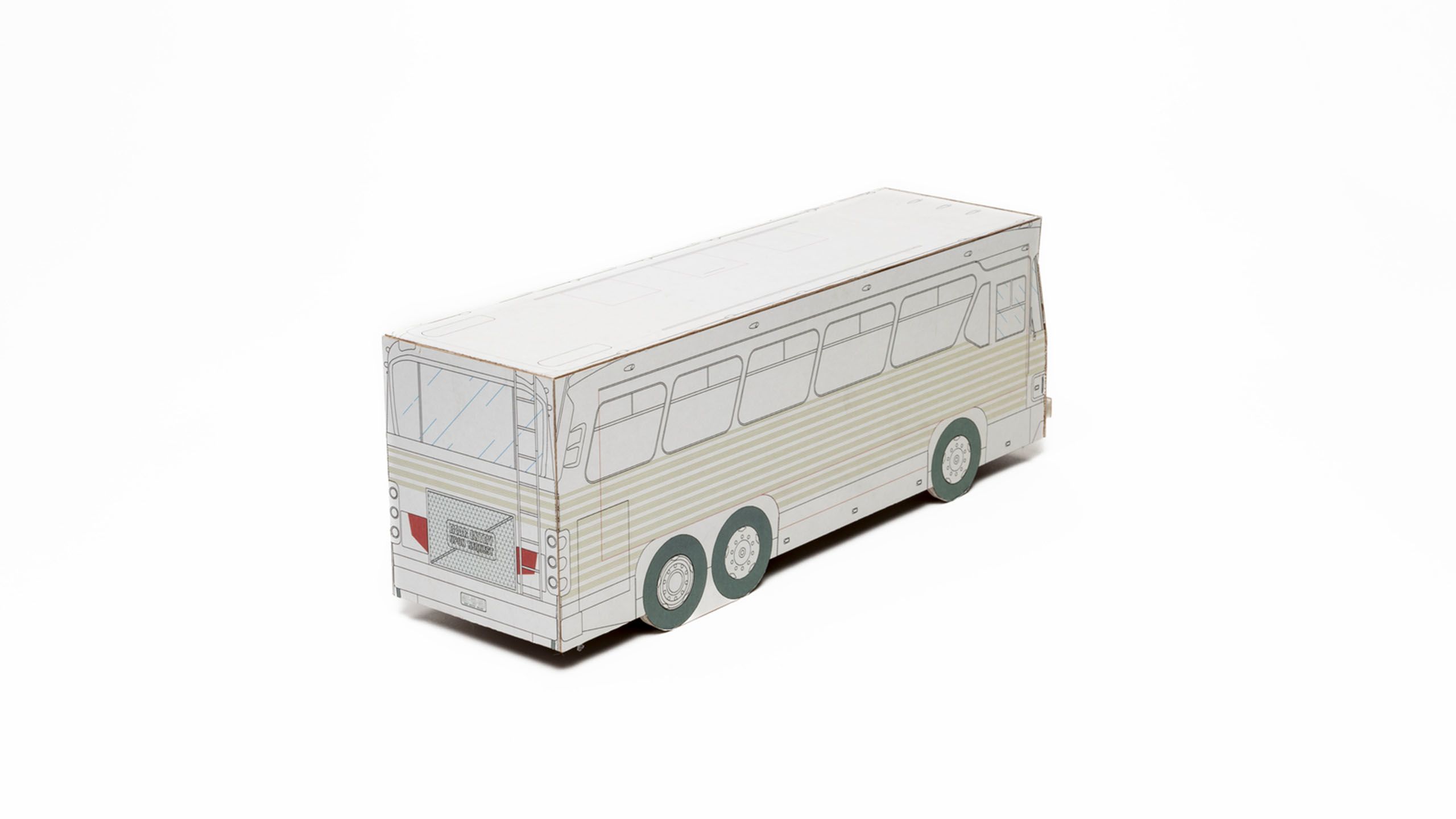 Three quarter side view of 3D bus model made of white cardboard with black lines depicting bus details, pale green striped panelling, grey/green tyres and red taillights. Printed text on rear grill reads ‘Rear Entry Upon Request’.