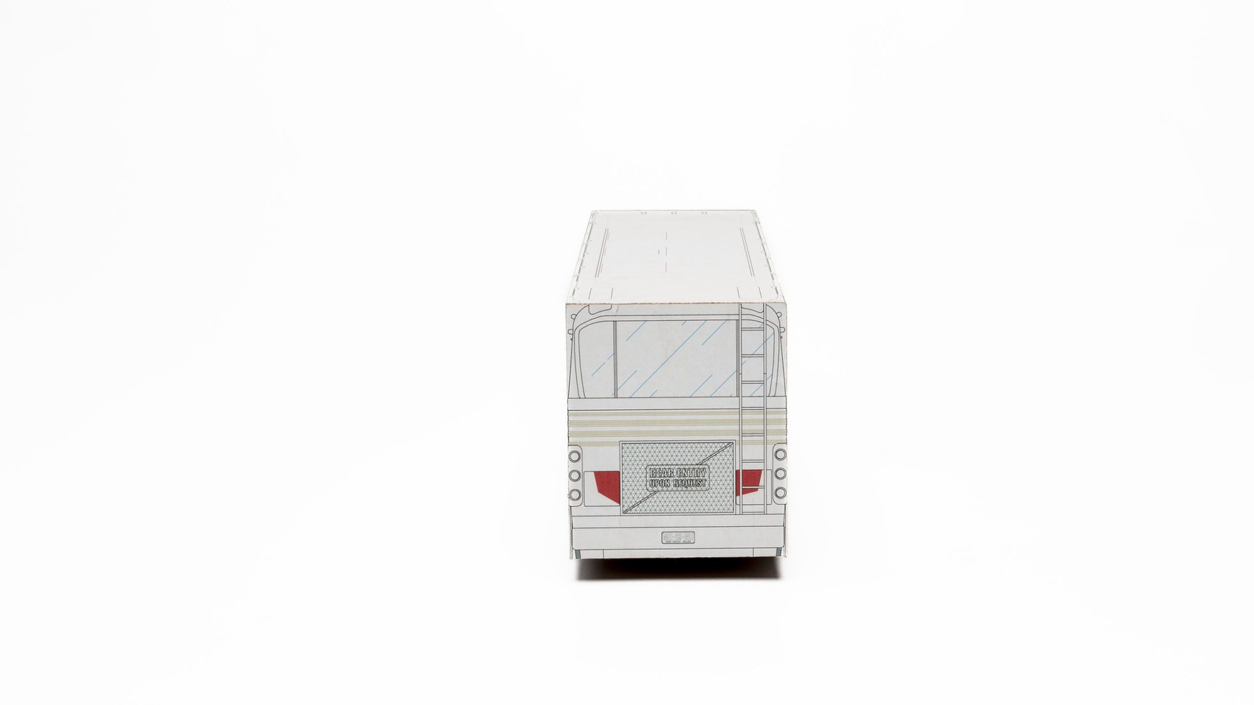 Rear view of 3D bus model made of white cardboard with black lines depicting bus details, pale green striped panelling and red taillights. Printed text on rear grill reads ‘Rear Entry Upon Request’.