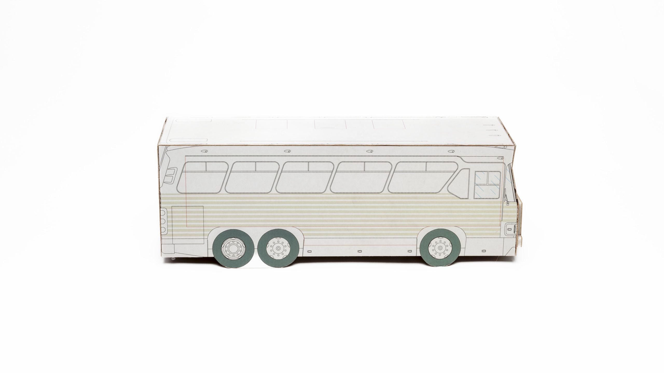 Side view of 3D bus model made of white cardboard with black lines depicting bus details, pale green striped panelling, and grey/green tyres.