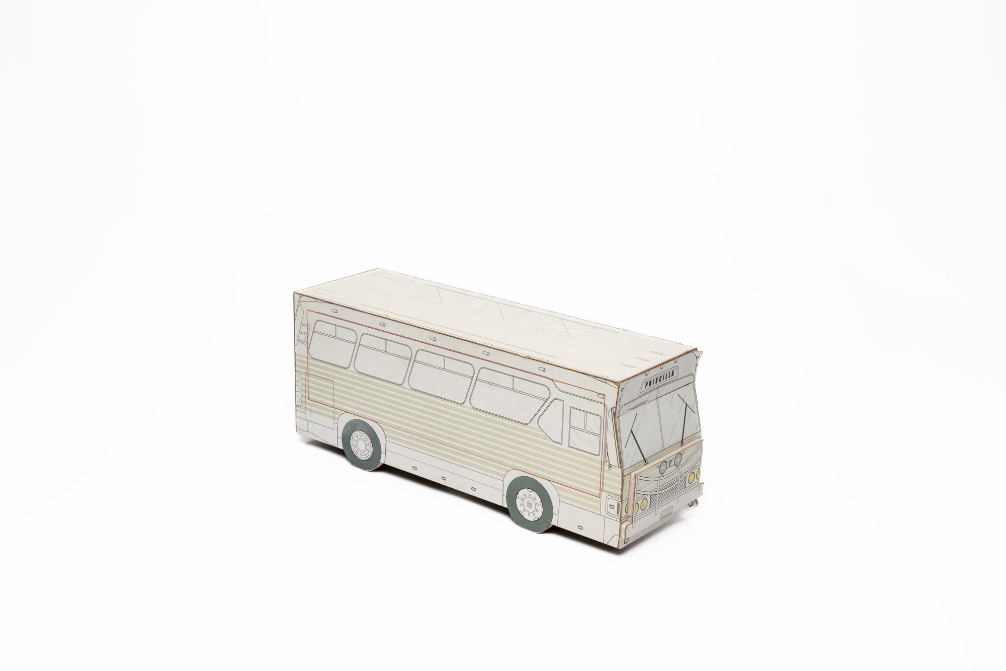 Three quarter side view of 3D bus model made of white cardboard with black lines depicting bus details, pale green striped panelling, grey/green tyres and yellow headlights. The name Priscilla printed in black above windscreen.