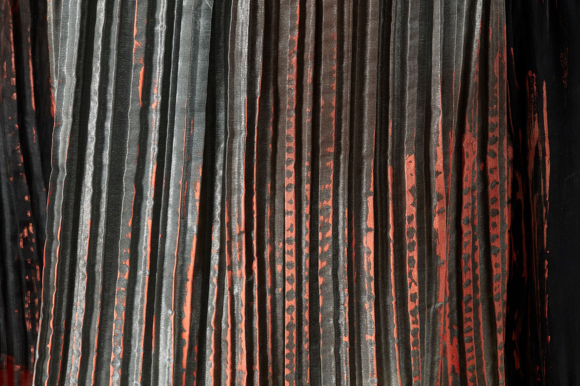 Close up of pleated and coated black and red fabric.