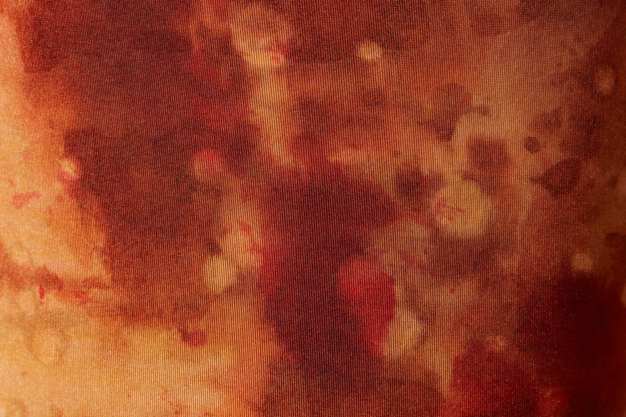 Close up of mottled orange and red fabric.