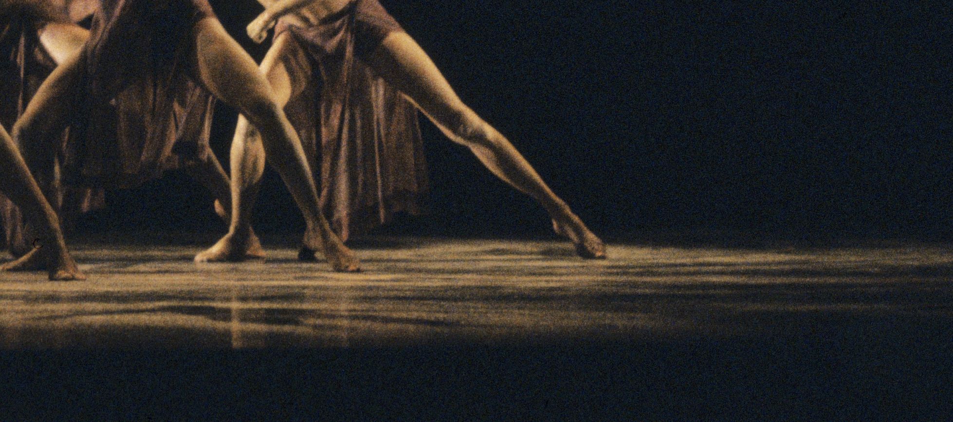 Dancers outstretched legs and bare feet on stage.