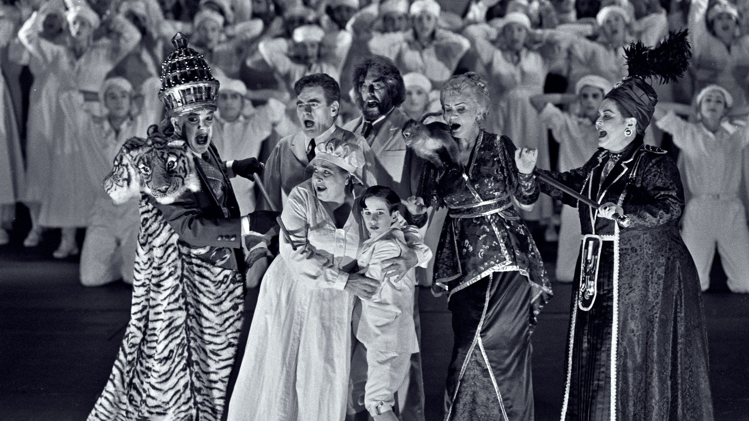 Black and white photograph of a group of actors on stage in elaborate costumes.