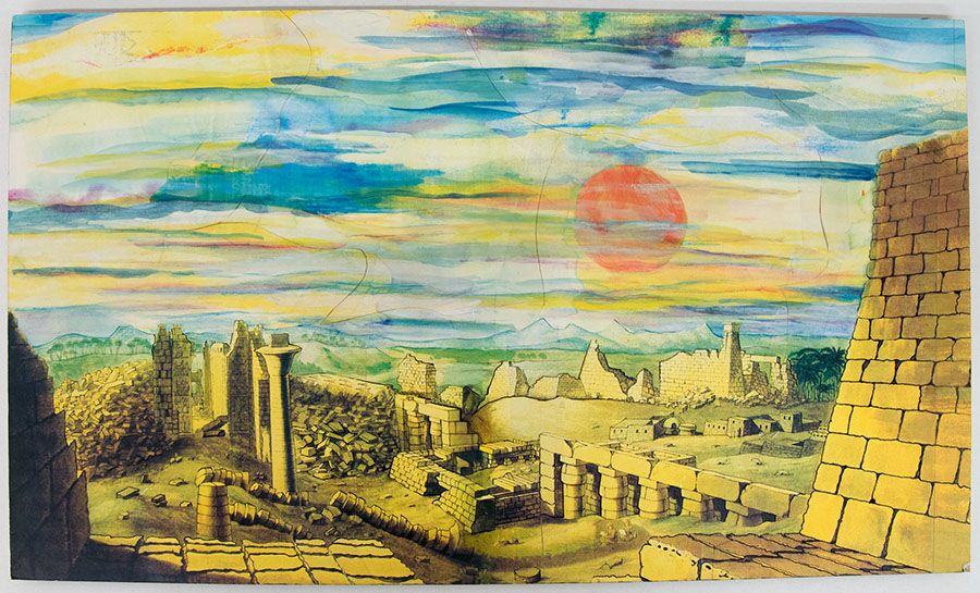 Painted scenery design featuring a landscape of ruined stone buildings with a large red sun in the background.