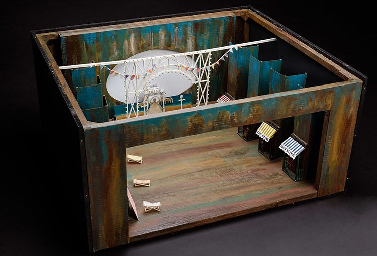 A wooden set model with hand-painted scenery showing a beach scene and St Kilda Pier