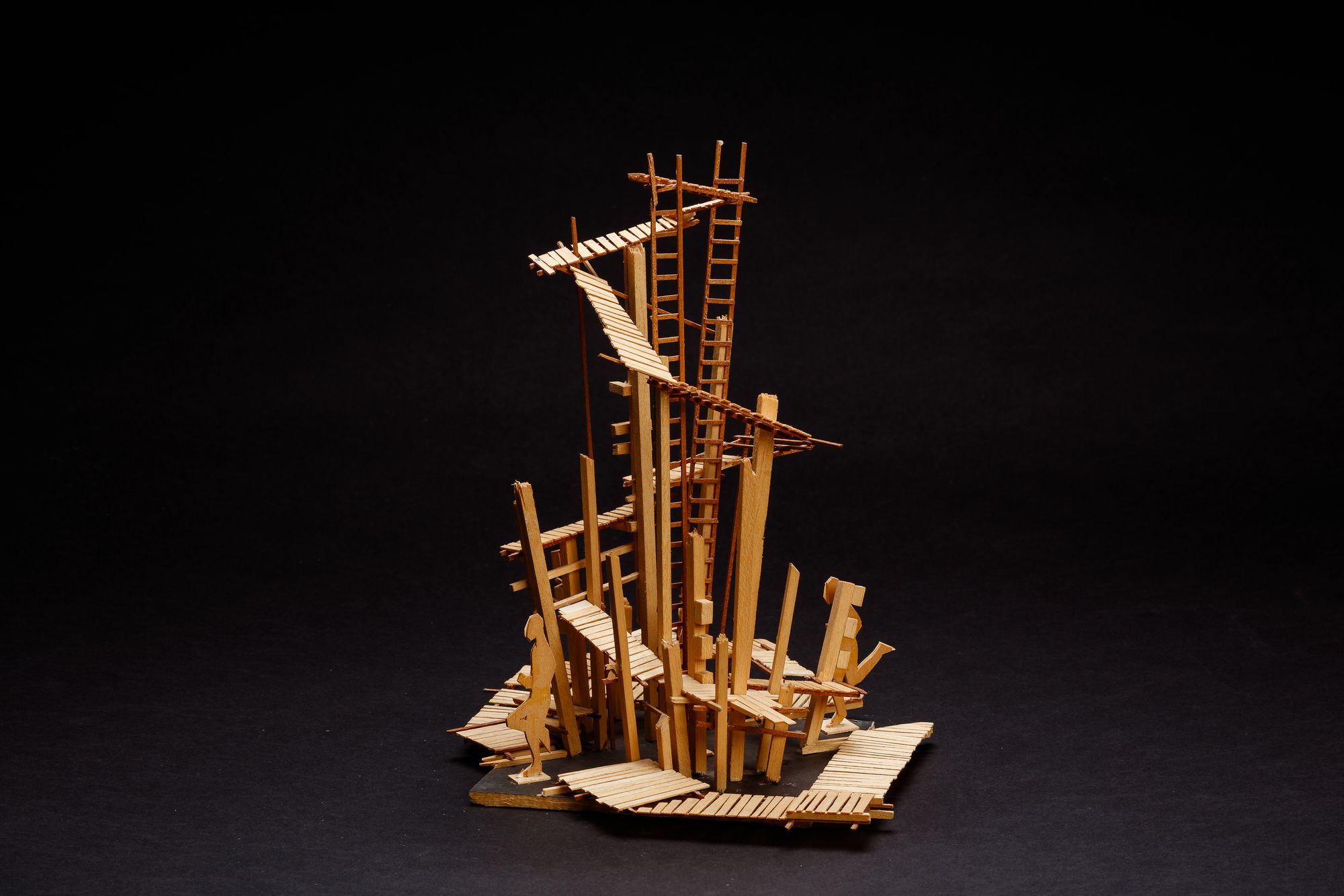 A complex sculptural balsa wood model showing a series of ladders and walkways.