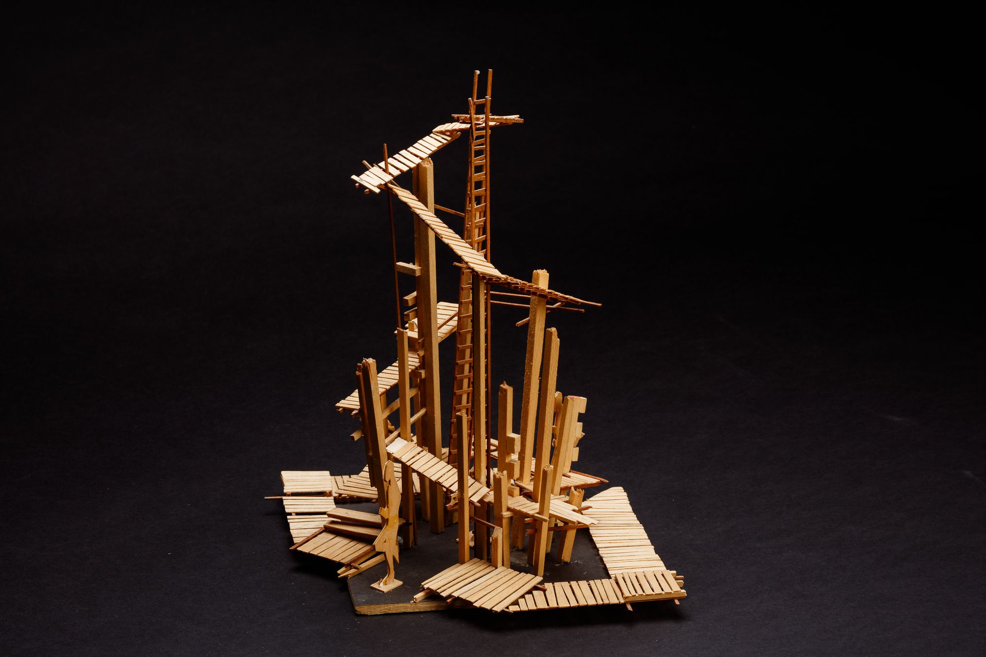 A complex sculptural balsa wood model showing a series of ladders and walkways.