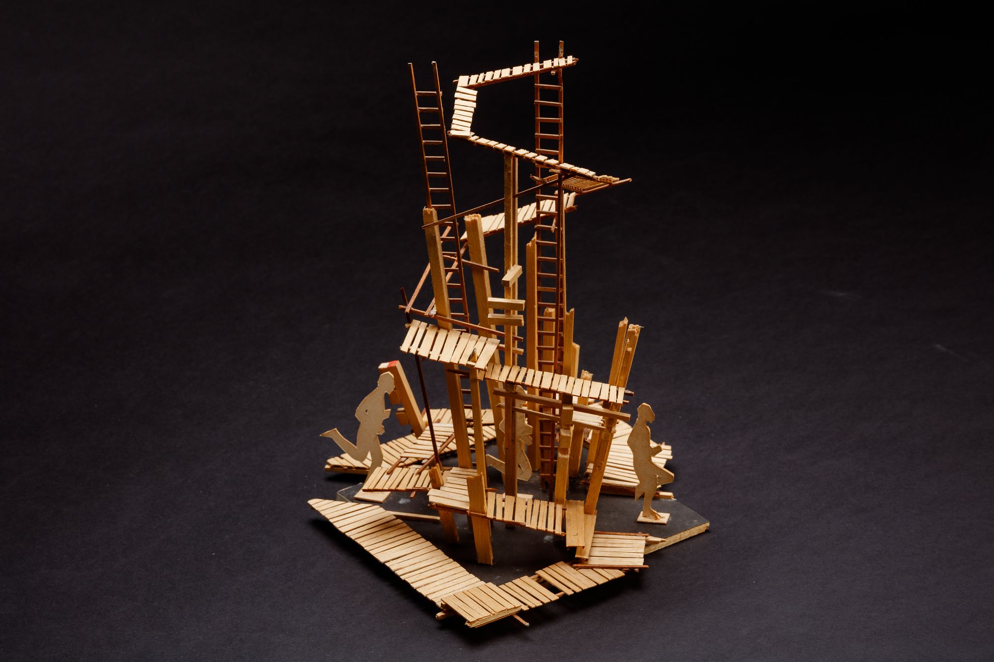 A complex sculptural balsa wood model showing a series of ladders and walkways.