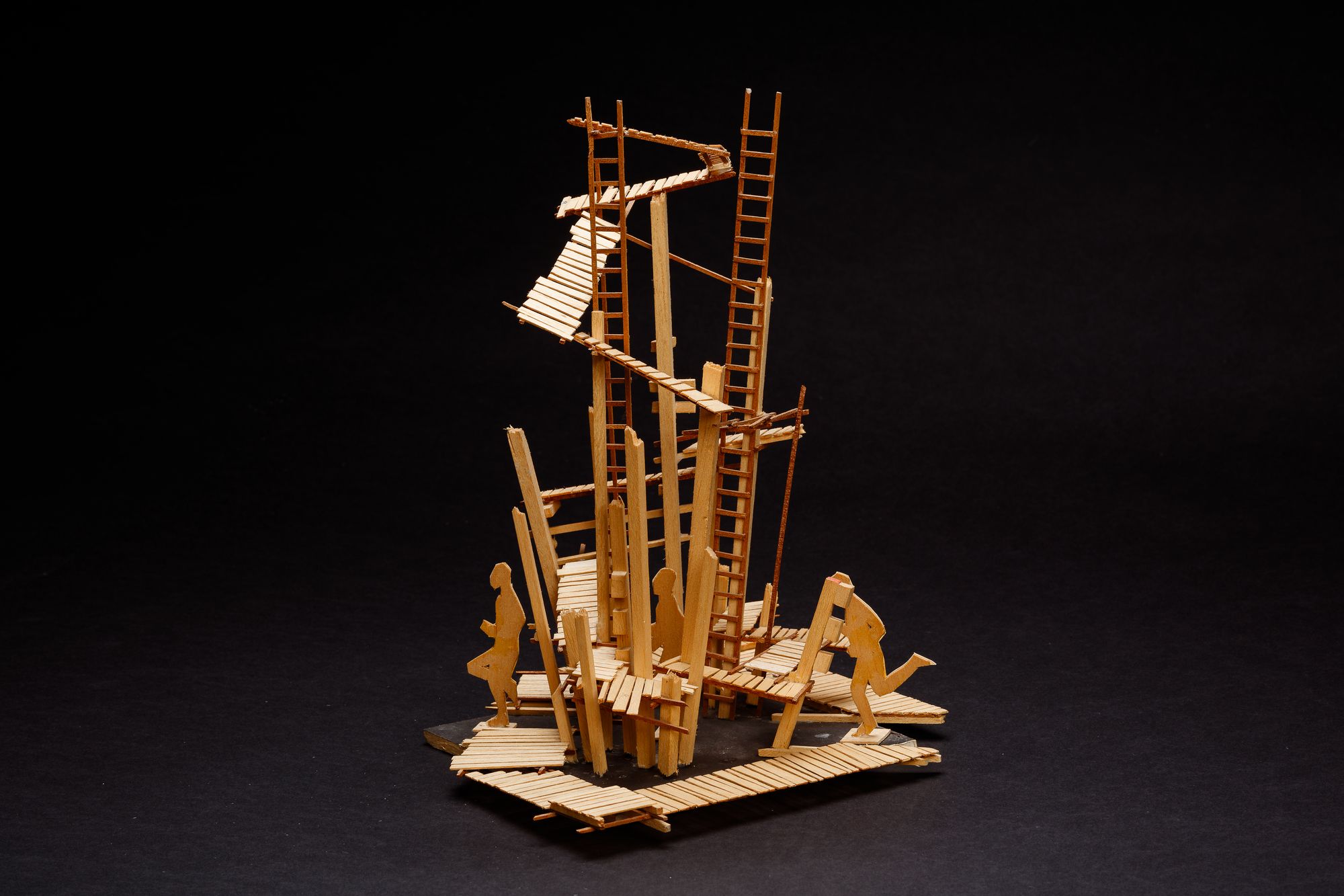 A complex sculptural balsa wood model showing a series of ladders and walkways.